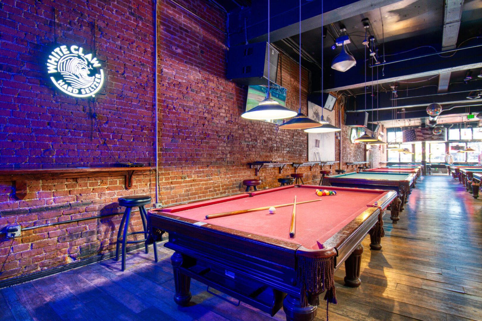 A pool table in a room with brick walls.