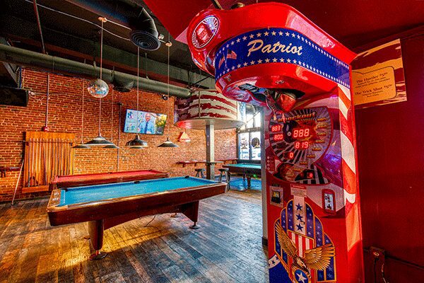A room with a pool table and a patriotic mural.