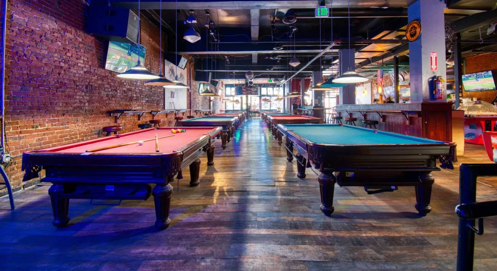 A row of pool tables in an empty room.
