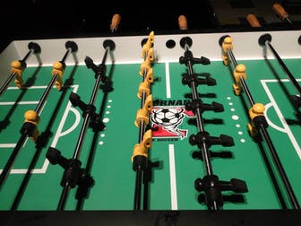 A close up of the foosball table with yellow handles.